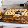 A modern vacuum sealer machine sits on a marble countertop with sealed food packages.